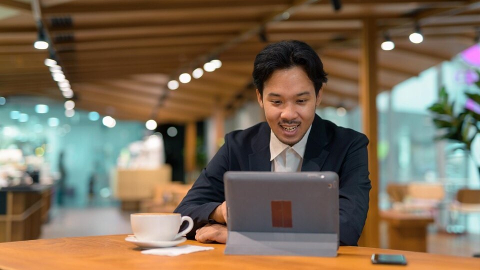 Young businesswoman using laptop while standing in cafe