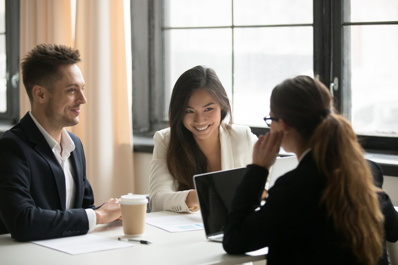 Female CEO talking with colleagues in office
