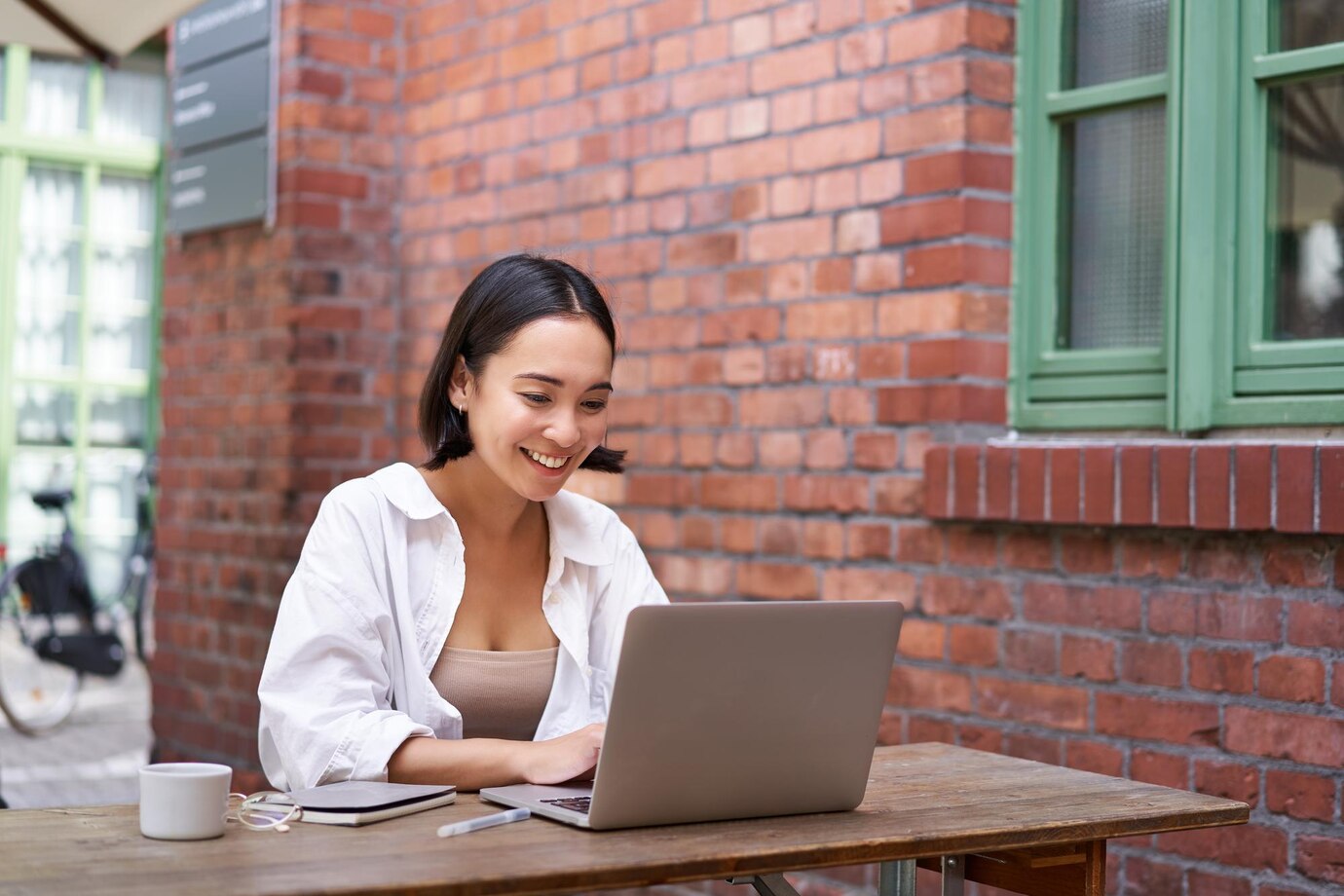 Happy asian girl watching video on laptop