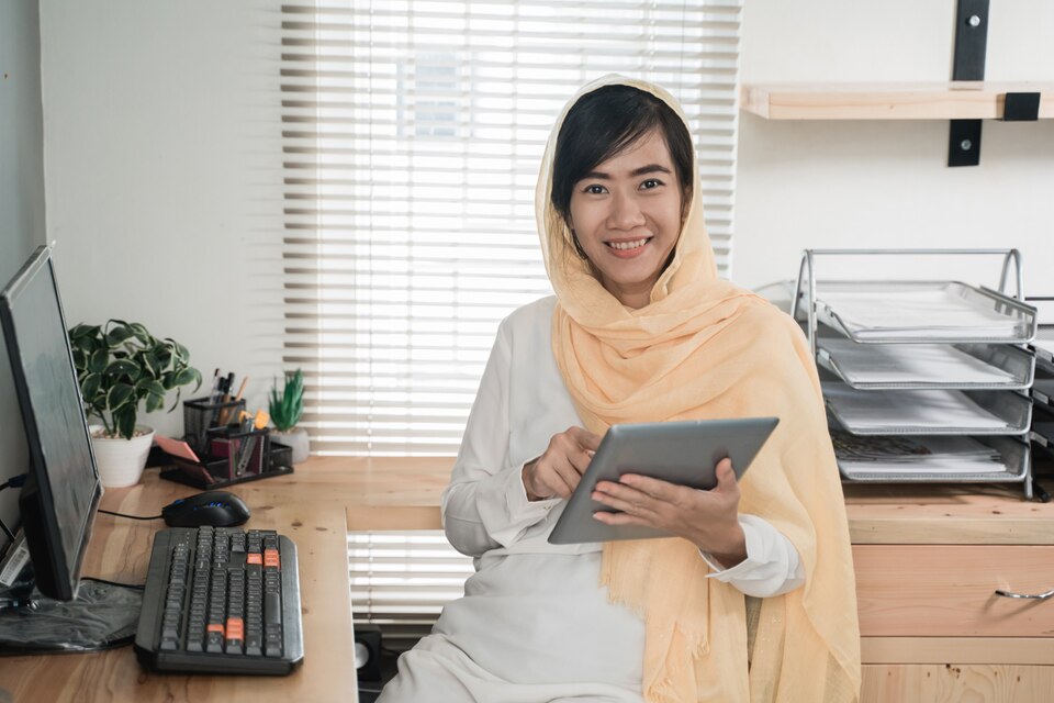 Muslim woman wearing hijab using tablet pc