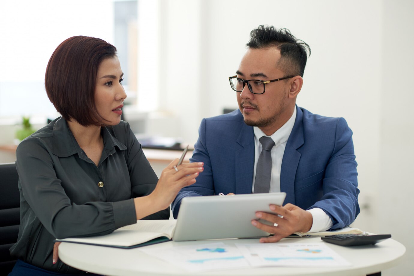 Asian man and woman in business attire sitting indoors