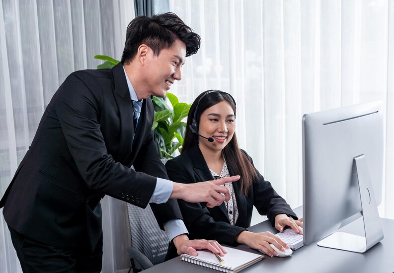 Manager helps female call center operator with customer support Jubilant