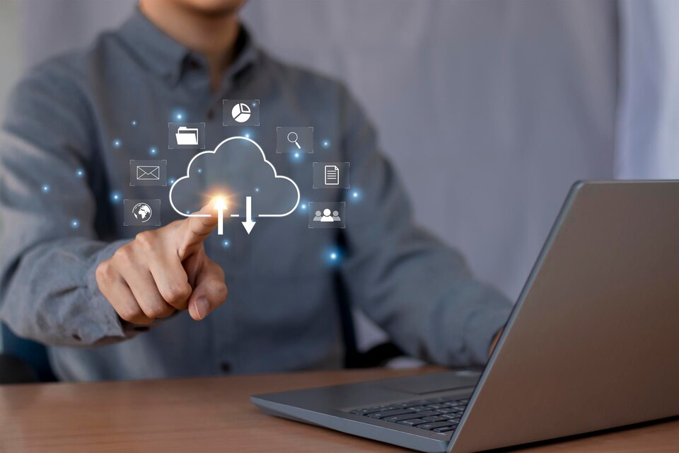 A man is pointing at a laptop with a cloud