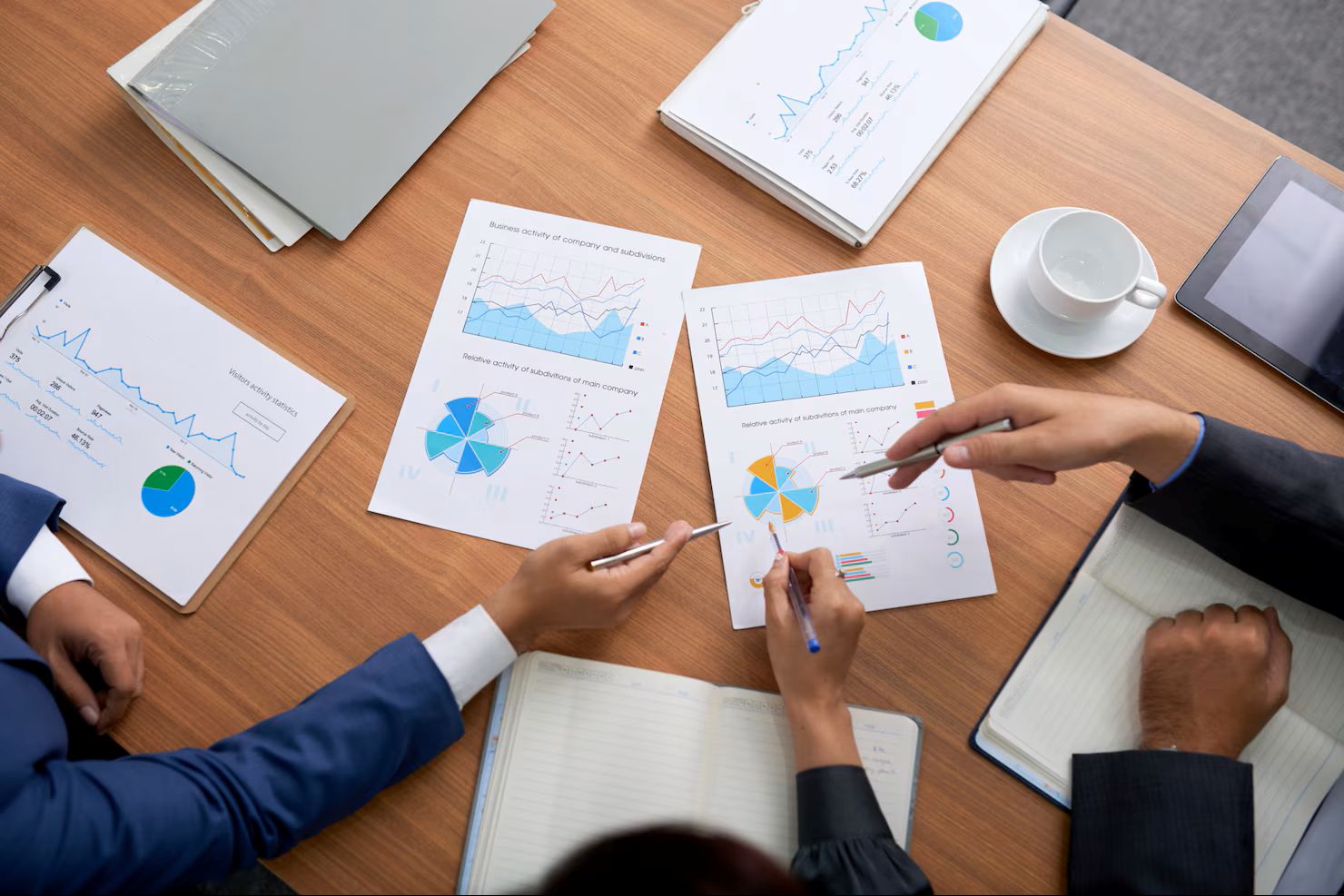 Top shot of three unrecognizable business people sitting at meeting